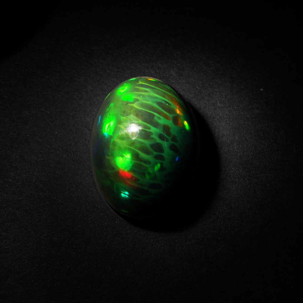 14.95 ct. Natural Play of Color Opal - ETHIOPIA: 14.95 ct. Natural Play of Color Opal - ETHIOPIA Shape - Oval Cabochon Color - Play of color Clarity - Opaque Ct. Weight - 14.95 ct. Origin - ETHIOPIA