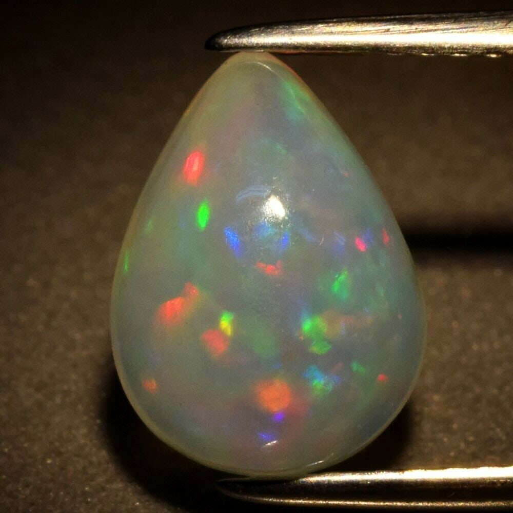 1.91 ct. Play of Color Natural White Opal - ETHIOPIA: 1.91 ct. Play of Color Natural White Opal - ETHIOPIA Cut - Pear Cabochon Color - Floral Flash Rainbow (White, Red, Orange, Green, Yellow, Violet, Blue Flashing) Ct. Weight - 1.91 ct. Dimensions - 1