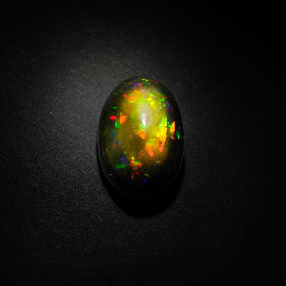 10.40 ct. Natural Play of Color Opal - ETHIOPIA: 10.40 ct. Natural Play of Color Opal - ETHIOPIA Shape - Oval Cabochon Color -Play of color Clarity - Opaque Ct. Weight - 10.40 ct. Origin - ETHIOPIA