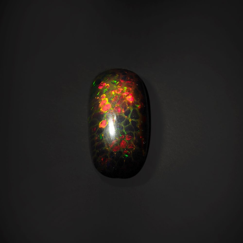 8.70 ct. Natural Play of Color Opal - ETHIOPIA: 8.70 ct. Natural Play of Color Opal - ETHIOPIA Shape - Oval Cabochon Color - Play of color Clarity - Opaque Ct. Weight - 8.70 ct. Origin - ETHIOPIA