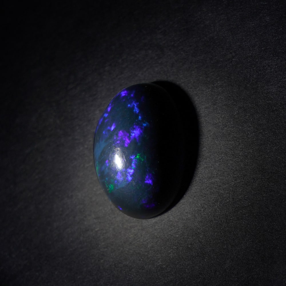 6.90 ct. Natural Play of Color Opal - ETHIOPIA: 6.90 ct. Natural Play of Color Opal - ETHIOPIA Shape - Oval Cabochon Color - Play of color Clarity - Opaque Ct. Weight - 6.90 ct. Origin - ETHIOPIA