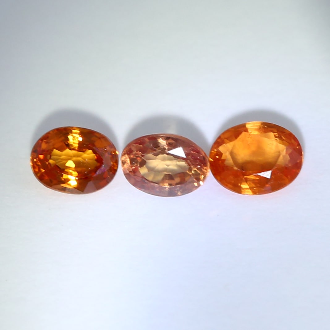 IGI Certified Set of 3 Padparadscha Sapphires and Sapphires - MADAGASCAR: IGI Certified Set of 3 Padparadscha Sapphires and Sapphires - MADAGASCAR Color - Pinkish Orange and Orange Clarity - VS Cut - Oval Mixed Cut Weight - 0.24 + 0.26 + 0.25 = 0.75 ct. Dimensions -