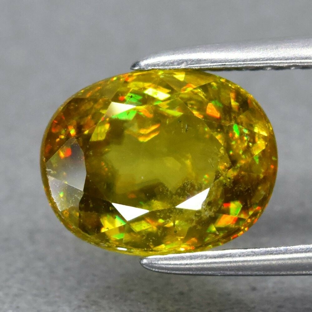1.95 ct. Natural Greenish Yellow Sphene - MADAGASCAR, AFRICA: 1.95 ct. Natural Greenish Yellow Sphene - MADAGASCAR, AFRICA Color - Greenish Yellow With Rainbow Spark Cut - Oval Clarity - SI1 Ct. wt. - 1.95 ct. Dimensions - 8.00 x 6.30 x 4.40 mm </