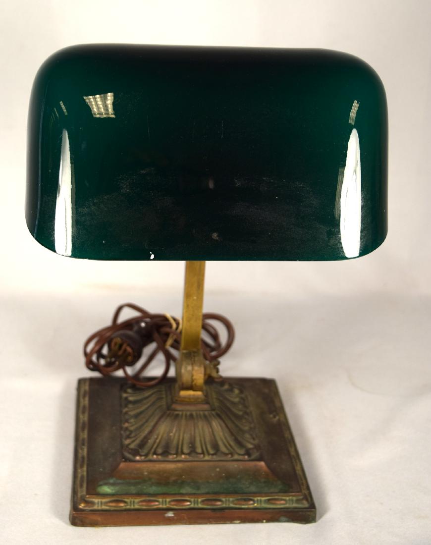 EMERALITE DESK LAMP:: Original cased green glass shade on brass base. Bears Emeralite name plate. Measures 13 inches tall with 7 inch wide base.
