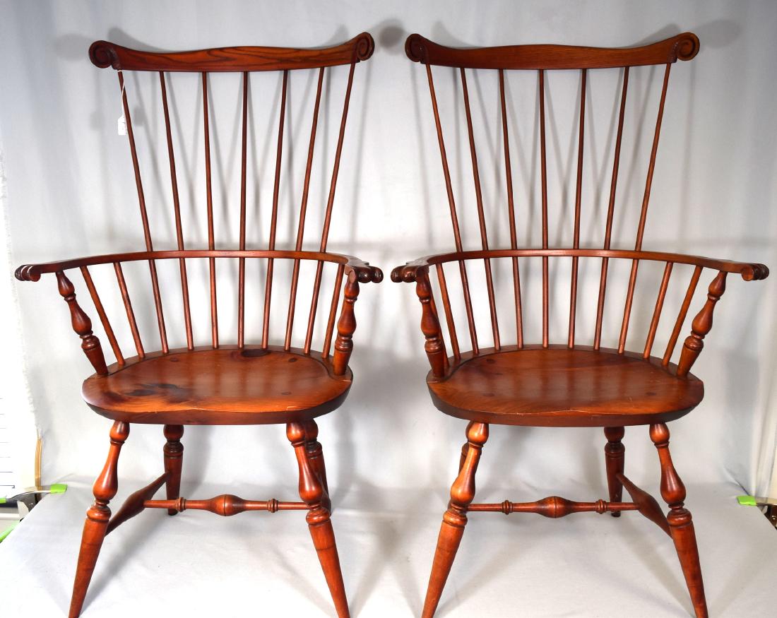 PAIR OF 20TH C. RHODE ISLAND STYLE COMB BACK WINDSOR: Shaped crest terminating in carved volutes, knuckled arms, and baluster-turned arm supports and legs. Mixed woods with red wash finish. Unsigned.