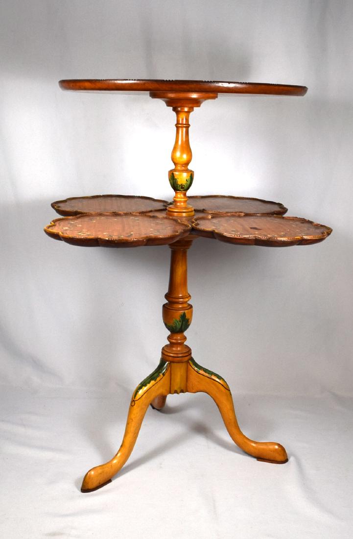 WURDEMAN TWO TIER TABLE:: Wurdeman Interior Design, Washington D.C. Maple with hand painted floral decoration. Tripod base, four leaf clover second shelf. Round top with hand painted cherubs, 16 ¾” in diameter x 27 ½ inche