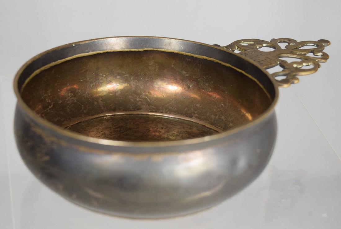 18TH C COIN SILVER PORRINGER BY JACOB HURD:: Jacob Hurd (Boston and Roxbury, Massachusetts 1702-1758). Measures overall 7 ¾ inches x 5 inches in diameter x 1 7/8 inches tall. Etched date on bottom 1757. Typical form with key hole handle with cr