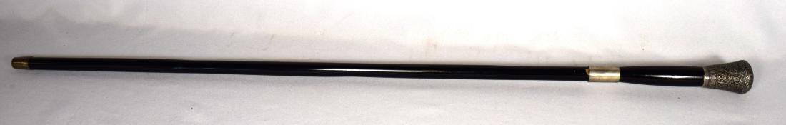 19TH/20TH C SWORD CANE WITH SILVER PLATE TOP:: Ebony shaft with ornate floral top, 35 inches long.