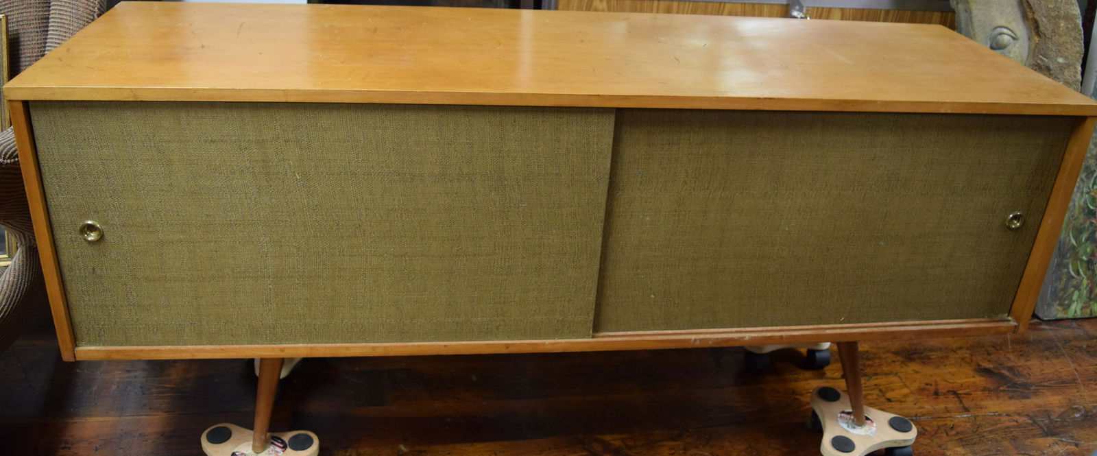 PAUL Mc COBB WINCHENDON PLANNER GROUP CREDENZA:: Ca mid-century modern. The solid birch or maple Paul McCobb Winchendon Planner Group credenza has green grass cloth sliding doors with original gold-plated ring or hardware and rests on tapered pegged