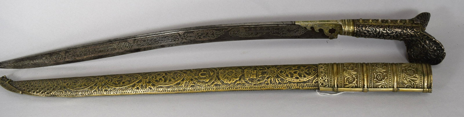 19TH C ISLAMIC OTTOMAN EMPIRE SILVER YATAGAN SWORD:: Curved single edge blade decorated both sides in silver inlay. Arabic calligraphic inscriptions and circular designs. Elaborate decorative handle with butterfly design. Silver plate repousse scabbard.