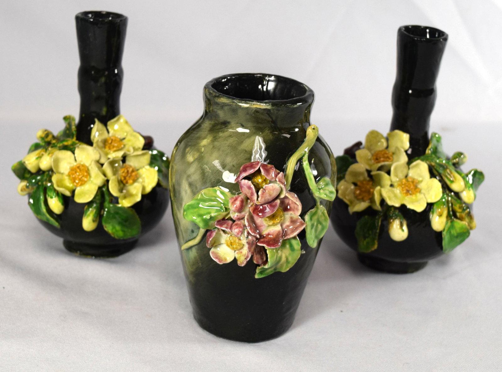 THREE T. J. WHEATLEY ART POTTERY VASES:: Three Barbotine vases with molded wild rose decoration. Barbotine is the French for ceramic slip, or a mixture of clay and water used for molding or decorating pottery. Pair of bottle shape and date