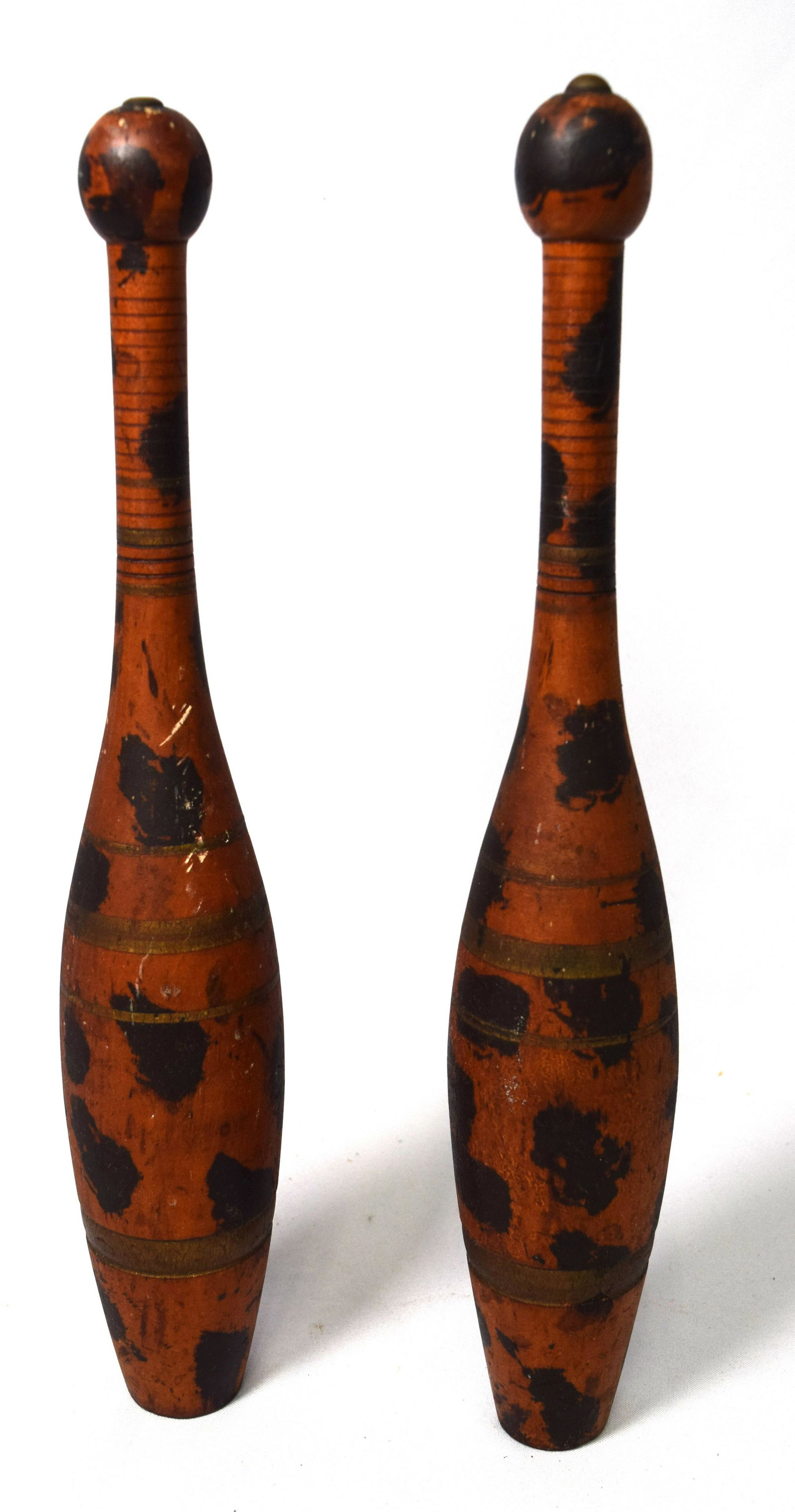 PAIR OF EARLY SPONGE PAINT DECORATED WOODEN INDIAN: Painted black splotches on dark rust colored ground. Highlighted with gold banding. Measures 15 inches tall.