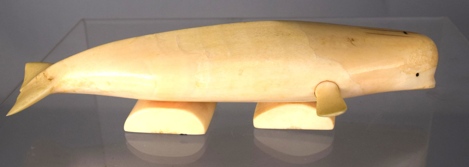 CARVED WHALE BONE FIGURE OF A NARQHAL WHALE:: Measures 7 1/2 inches long. Set on double whale bone base.