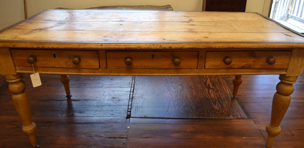 19TH C SCRUB PINE HARVEST TABLE:: Turned legs, three dove tailed drawers with brass mushroom pulls. One-inch brass band applied to perimeter. Three legs pine, one oak. Measures approximately 70 inches x 35inches x 3 1 1/2 inches tall.