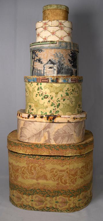 MID 19TH AMERICAN WALLPAPER HAT BOXES.: Civil War era. Six boxes. Largest 15 x 11 x 12 inches to the smallest 2 1/2 x 4 1/4 x 3 1/2 inches. Some newspaper lined. Large one dated with newspaper 1854. Various condition. Wear some stains.