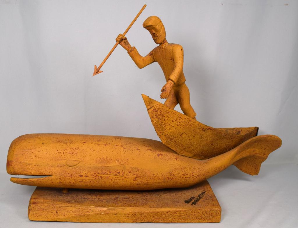 MOBY DICK ROBERT MALALIK FOLK ART CARVING: Ca 20th century. Carved and painted in yellow mustard paint. Whaler in boat with harpoon atop fin back whale. Signed in black, which is illegible. Wooden with tin boat. 36 inches long x 24 inches tall