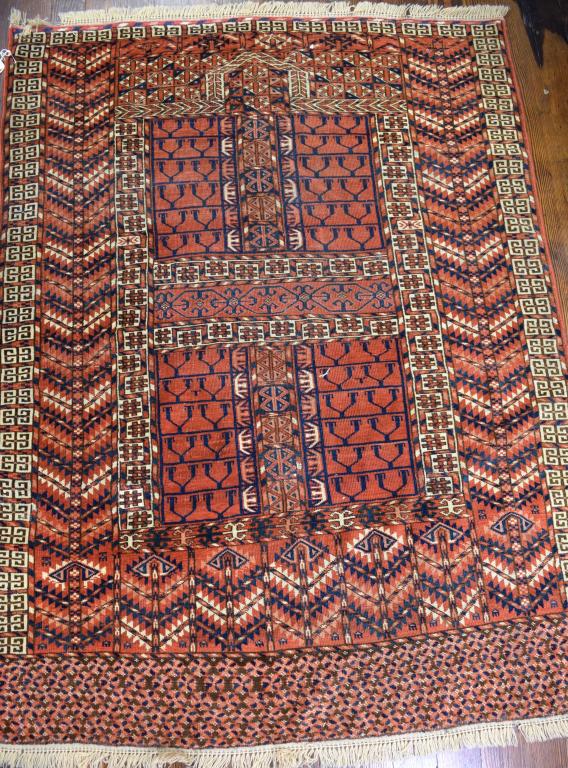 ANTIQUE TEKKE TURKOMAN ENSI PRAYER RUG:: Antique Tekke prayer rug. Directional. Central Asia, ca 1880. Wool and natural dyes. Various detailed geometric field designs, ram's head border. Colors of reds, navy and cream. Measures 62 inches x 4