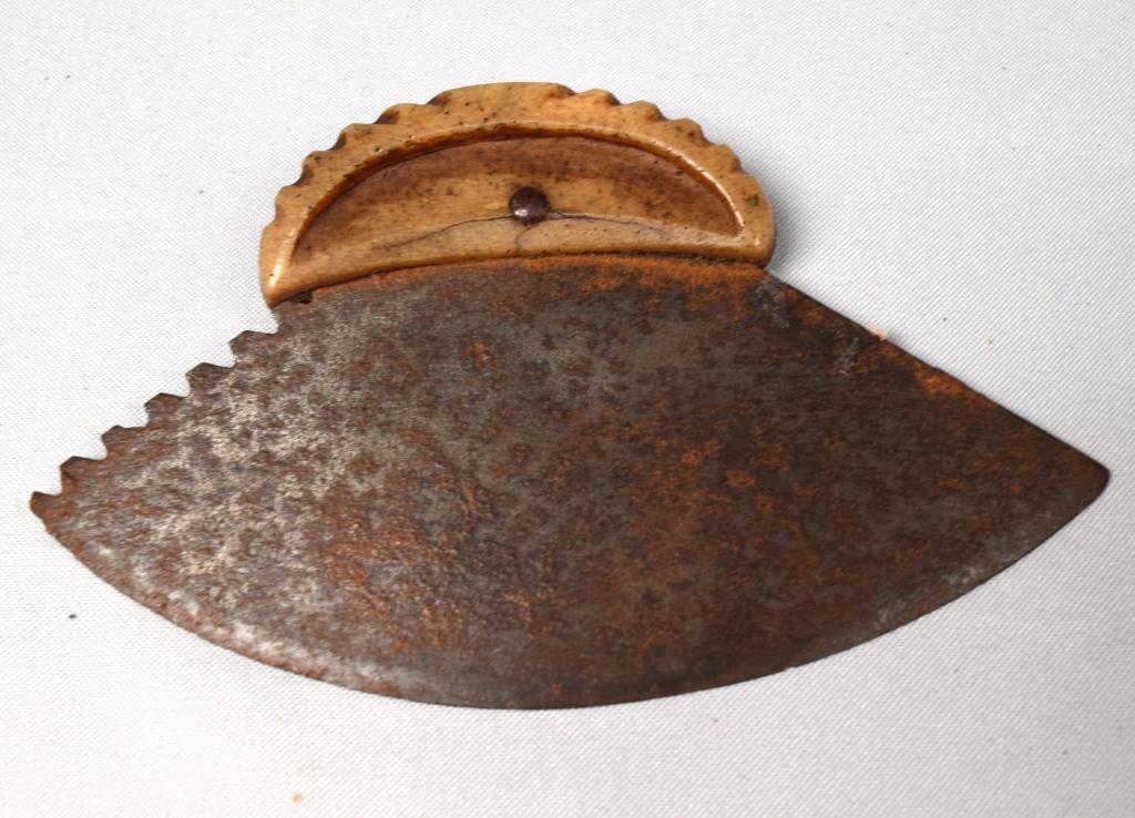 EARLY CARVED ESKIMO BONE ULU: Whale bone or bone carved handle uku with steel serrated blade. Measures 6 inches wide x 3 1/2 inches. Good condition.