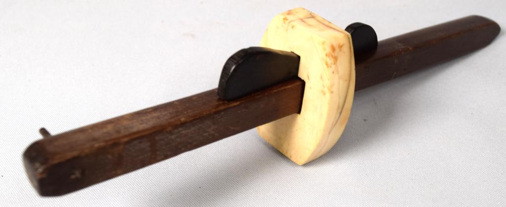 WHALE BONE, EBONY & MAHOGANY MARKING SCRIBE: Three piece construction, 9 inches long. Whale bone and mahogany with shaped ebony wedge. Good condition.