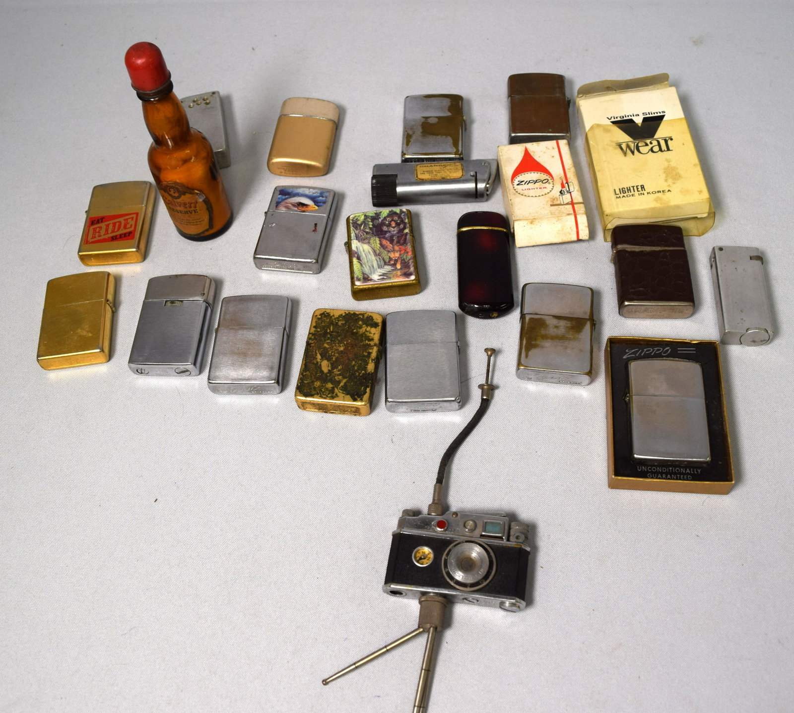ASSEMBLED GROUPING OF VINTAGE CIGARETTE LIGHTERS: 21 lighters. Mostly zippo lighter. Some worn, some not working.