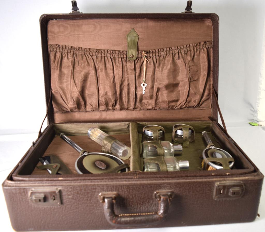 ART DECO TRAVEL VANITY BRUSH & MIRROR SET: Ca 1920s. Chrome and enamel set. Original carry case with interior having two layers. 8 pieces, include mirror and bottles and etc. Has key. Good condition.