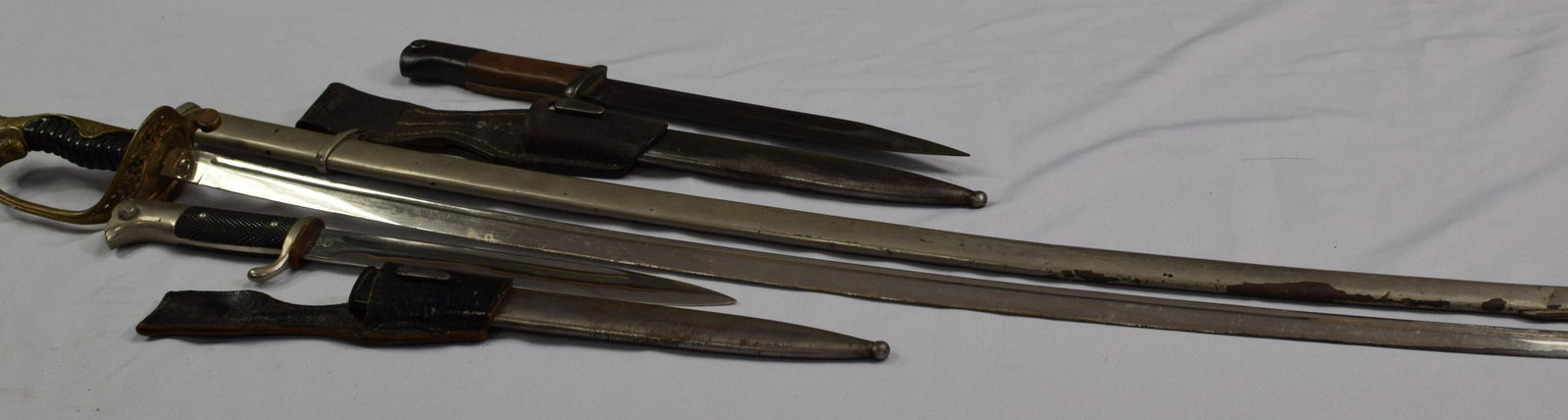 (3) WWII MILITARY WEAPONS, JAPANESE SWORD, GERMAN: Bayonets. Ca 1920's-1940. 1) Japanese military WWII sword and scabbard. (Loose handle and wire loose). 2) German WWII dress bayonet. Third Reich dress bayonet. Nickeled pronounced eagle headpommel and