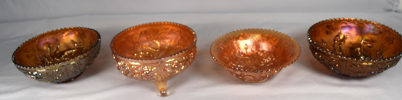 (4) CARNIVAL GLASS BOWLS: Consists of 1) Rose pattern in marigold, 7 1/2 inches diameter. Good condition. 2) Rose pattern footed bowl, in marigold, 7 1/2 inches. Good condition. 3) Two rose pattern bowls. Both inamethyst, 8 in