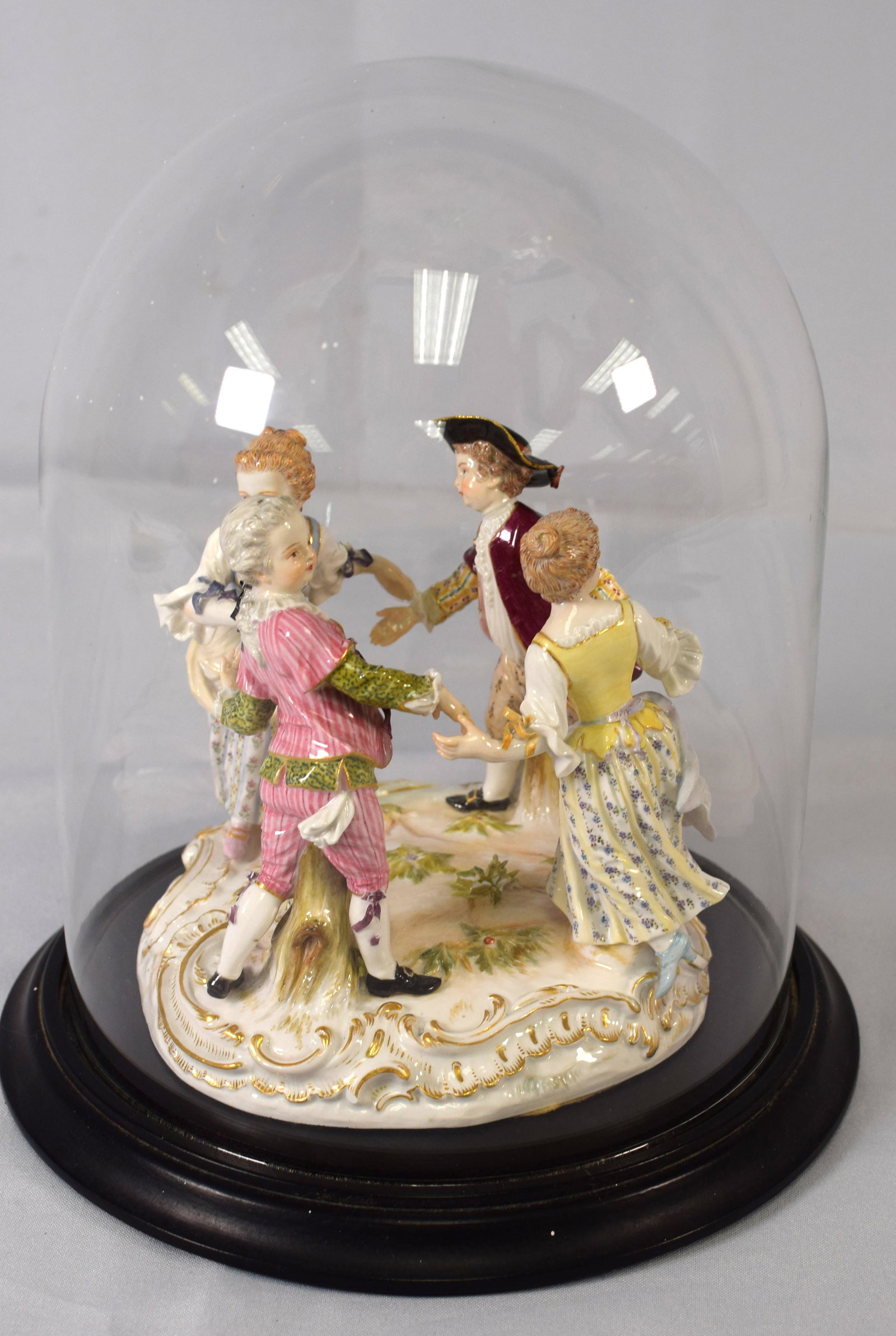 MEISSEN PORCELAIN FIGURAL GROUP: Late 19th century. Depicting a game of Ring Around the Rosie, having crossed swords in underglaze blue, and retailer labl Gilman Collamore & Co. New York. incised 2728, impressed 143. Diameter 7inches