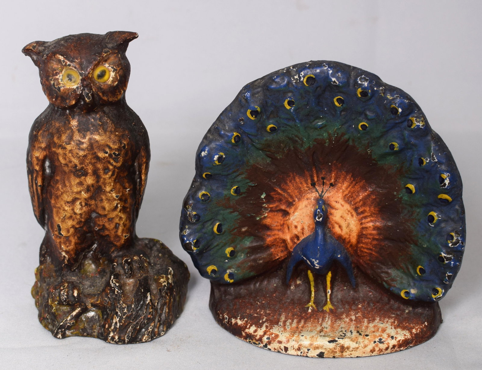 (2) ANTIQUE CAST IRON DOORSTOPS: 1) Cast Iron Peacock doorstop, Early 20th C. Hand-painted, unmarked doorstop measures approx. 6 inches tall. Good condition. 2) Hand-painted cast iron owl doorstop. 6 1/2 inches tall. Circa1920's. Goo