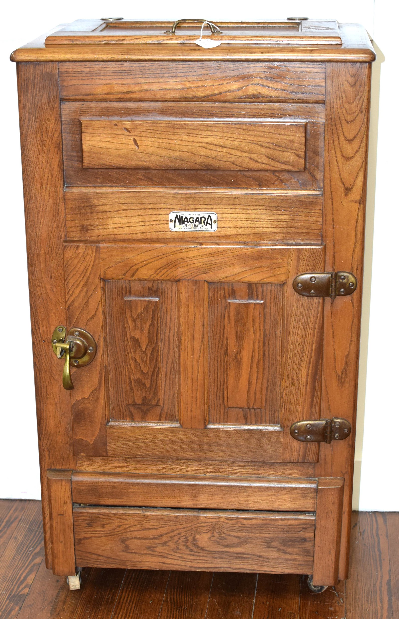 HEINZ & MUNSCHAUER SMALL OAK ICE BOX REFRIGERATOR: Small antique oak Heinz and Munschauer Niagara brand refrigerator circa 1910. Zinc or aluminum lined interior and drip tray with brass accents and original wheels. Measures 39 inches x 14.5inches x 22