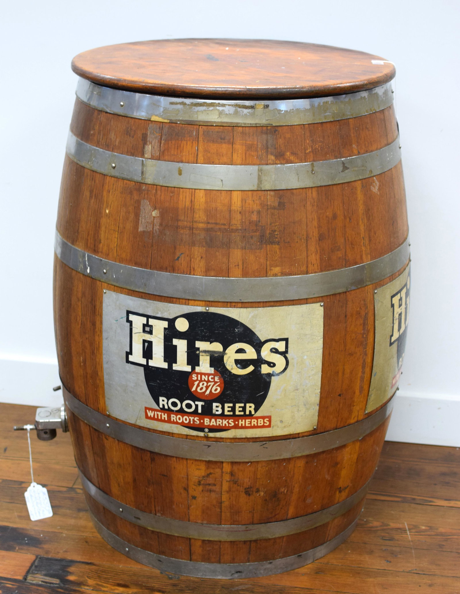 1950S HIRES ROOT BEER BARREL DISPENSER, OAK: Barrel with two metal advertising signs. Chrome bands and two spigots. One spigot handle is cracked. Hored dispensing equipment label on spigot side. 22 inches diameter at top and 35inches tall. Good 