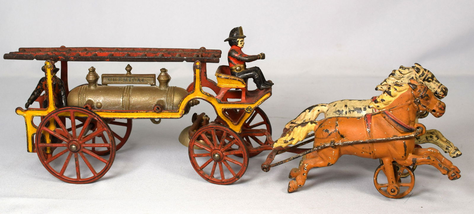 HARRIS HORSE DRAWN CHEMICAL FIREMAN WAGON TOY: Ca.. 1880s. Cast iron American toy. Pull toy with original bell. Features original figures and original two ladders, drawn by two horses, marquee on tank reads, Chemical, nice color combinations. 20 i