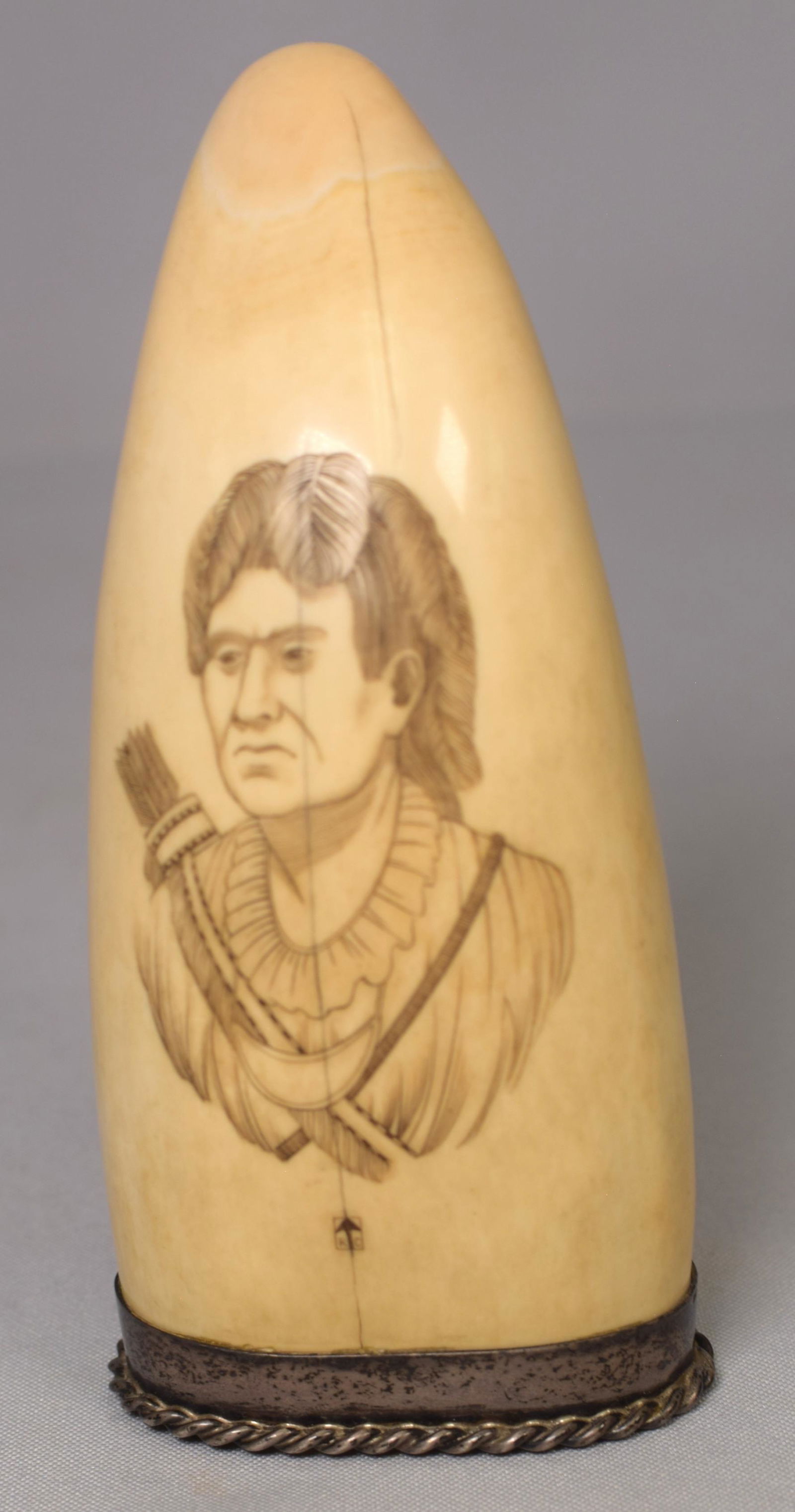 STERLING MOUNT SCRIMSHAW WHALE TOOTH: Fine early sterling silver mounted American Indian scrimshaw whale tooth. 6 inches tall. Monogrammed mark with whaling iron RC for scrimshander Ryan Cooper. Decorated one side. Good condition. 433gram