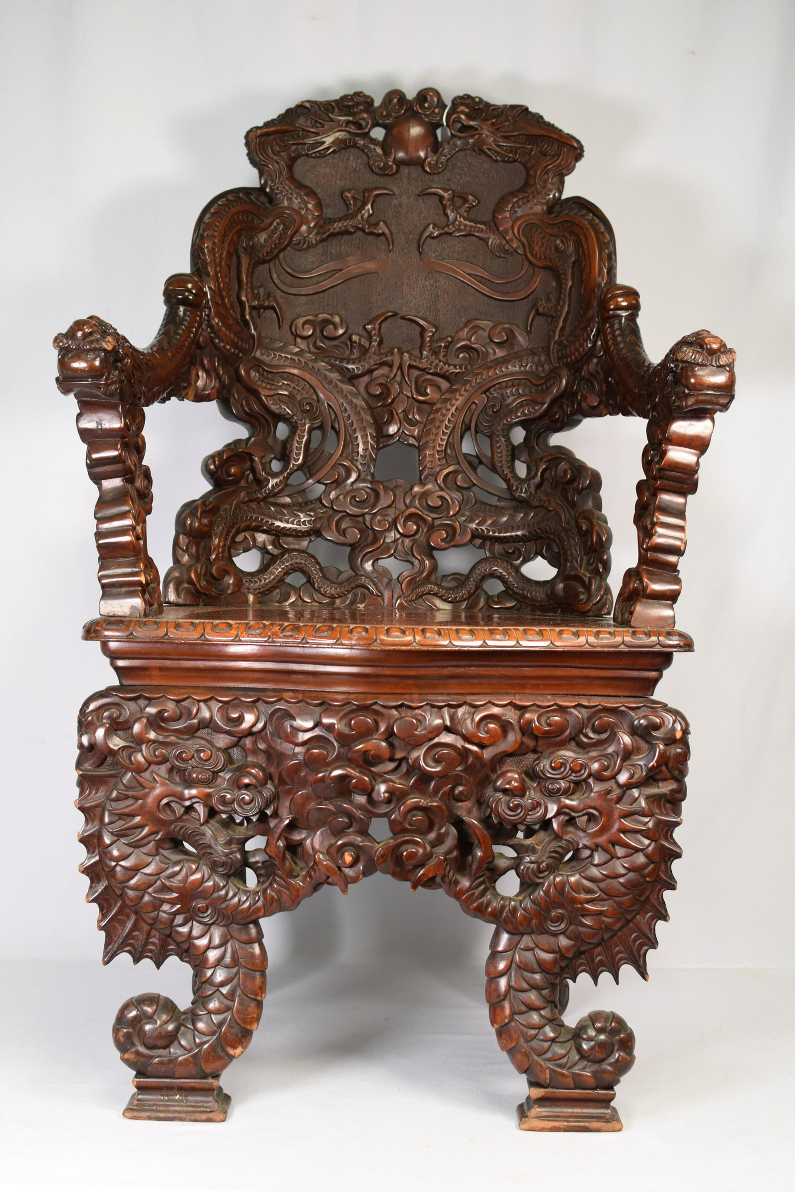 19th CARVED ORIENTAL DRAGON ARM CHAIR: Fine carved oriental arm chair. Round back with dragons with pearl (chasing pearl of knowledge). Beautiful carved front legs and arms. Solid seat. 43 inches tall x 24 inches wide. Minor smallchips. Go