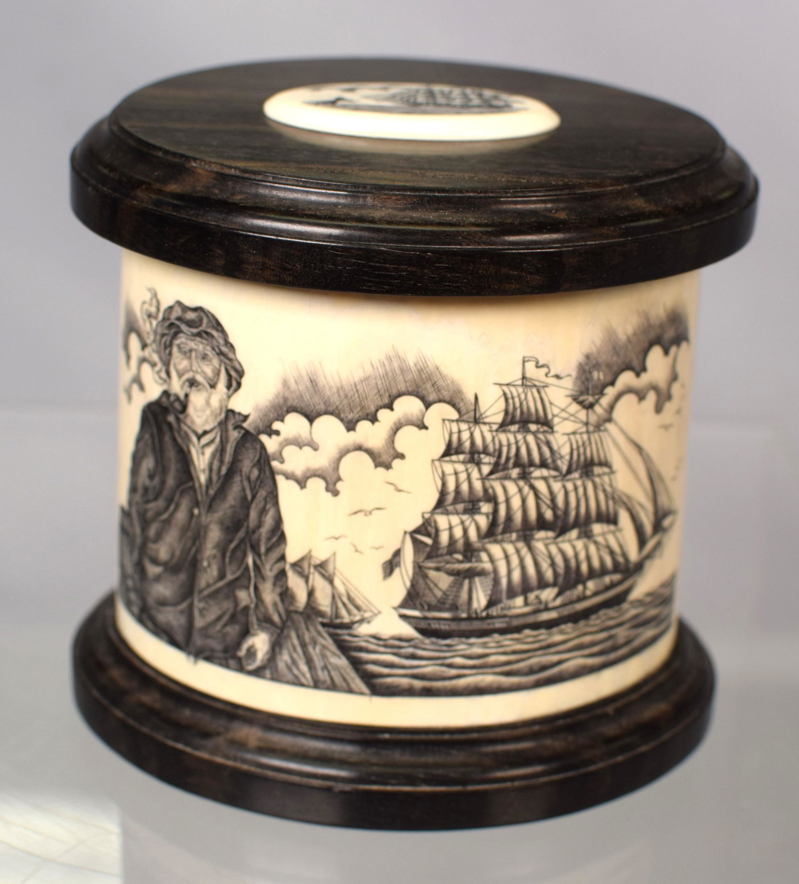 RAYMOND MARTIN SCRIMSHAW BOX: Wonderful oval box. Scrimshaw 360 degrees around with ebony top and scrimshaw whale whale scene oval plaque. Signed Raymaond Martin. 4 1/4 inches tall x 4 1/2 inches x 3 1/2 inches. 3 scenes. 1)Old sa