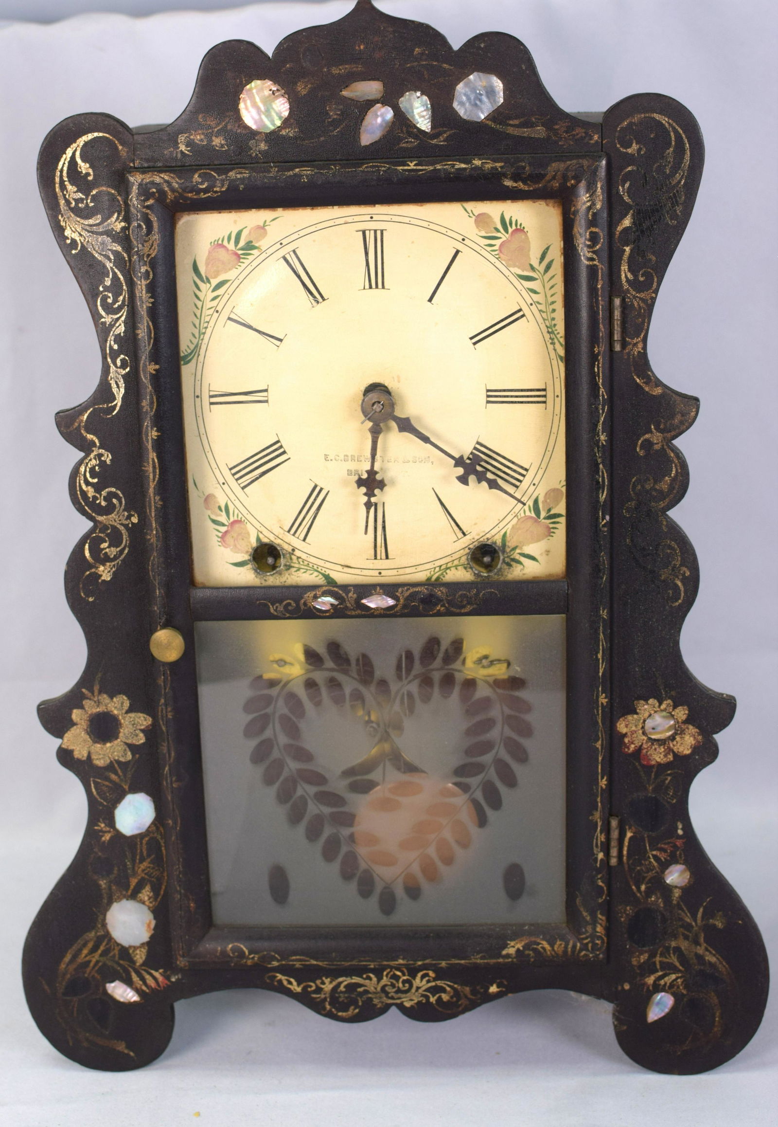 E.C. BREWSTER BLACK LACQUER MANTLE CLOCK: 19th century Brewster shelf clock, 8 day time and strike. Original painted metal face signed E.C Brewster & Son, Bristol, Conn. (worn). Black scalloped case with gilt scroll and floraldecoration and i