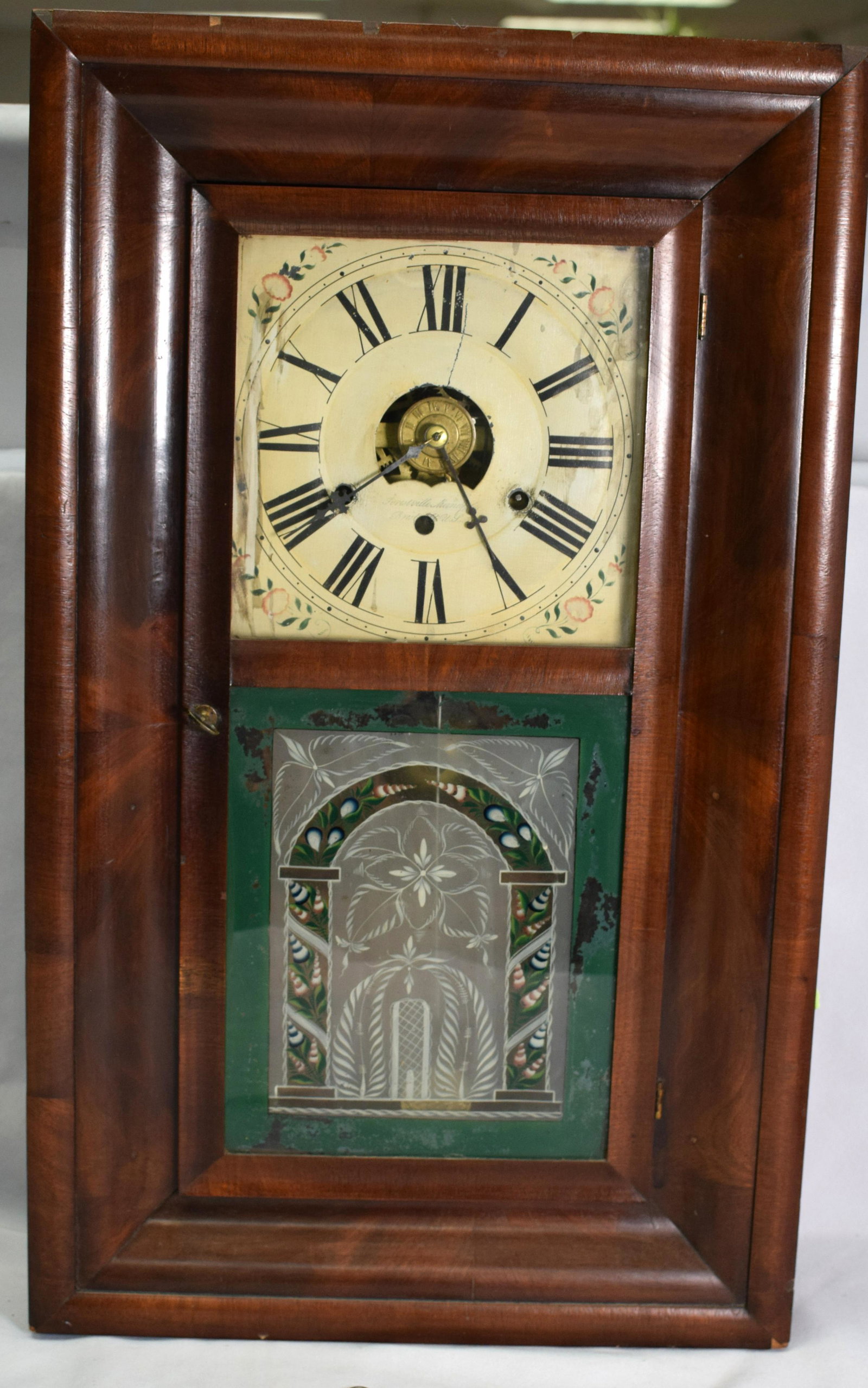 J.C. BROWN OGEE CLOCK: Rosewood and rosewood veneer case. Painted metal face with floral accents and Roman Numerals (some loss), open escapement movement. Signed Forestville Manufacturing, Bristol, Conn. USA.Panel with deta