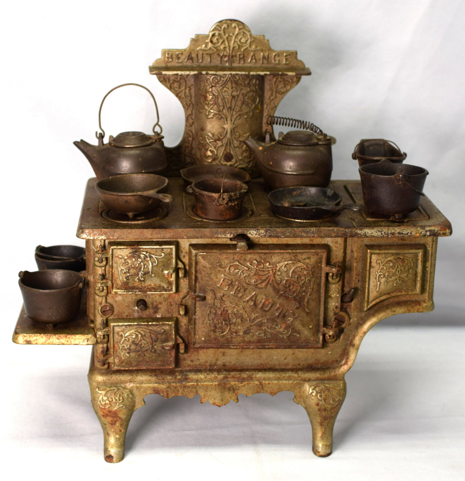 KENTON CHILD'S NICKEL PLATED CAST IRON STOVE: 19th cast iron child's toy. Marked Beauty Range. Stove with 11 iron kitchen accessories or pieces. Has all the iron top parts for the stove. Some loss to plating and some surface rust. Everythingworks