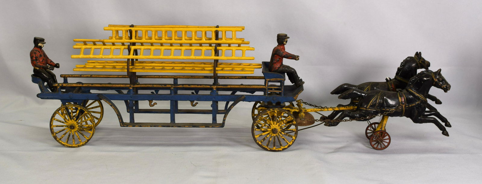 ANTIQUE OVERSIZE CAST HOOK AND LADDER: This is an oversized cast iron, 2 horse drawn hook and ladder. Beautiful paint, some loss, not much. Bell under driver that rings as the coach drives. Oversized at 29 in. long. Complete with 2 drivers