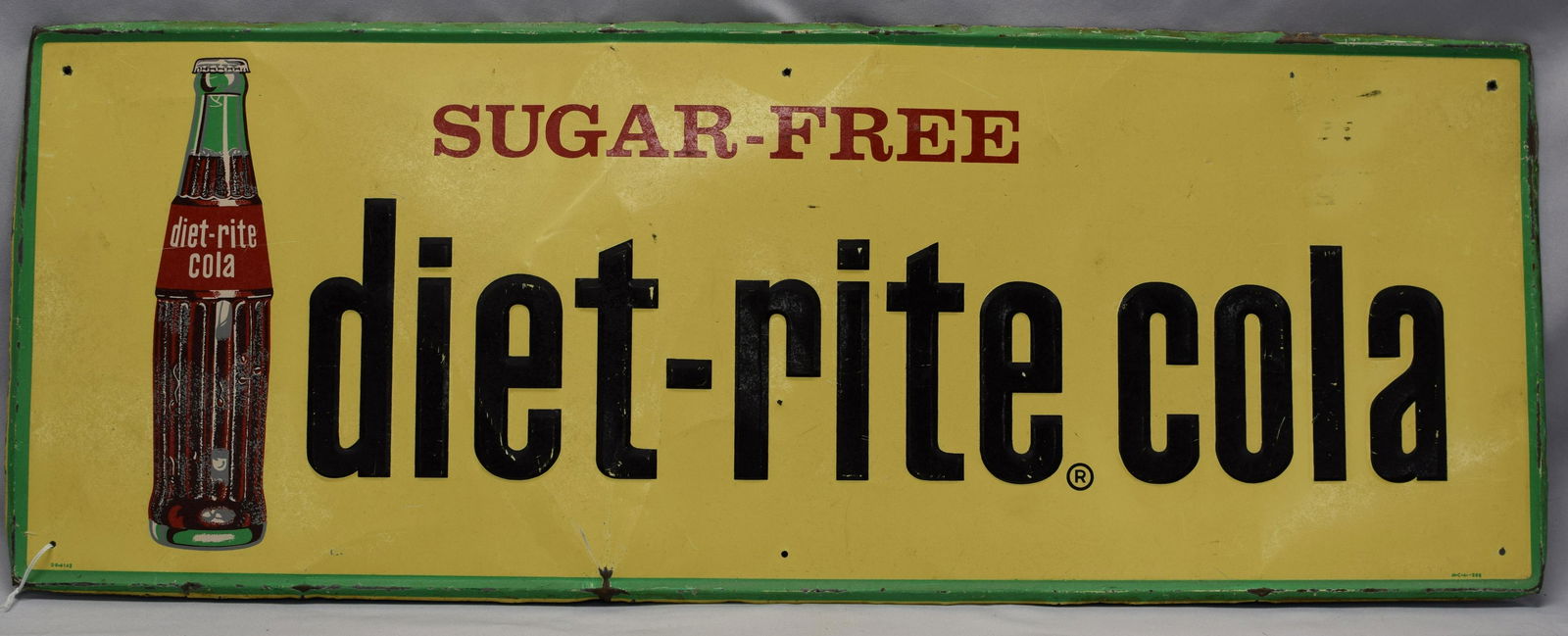 DIET RITE COLA ADVERTISING SIGN: Large metal advertising sign for Sugar-Free Diet-Rite Cola in vibrant yellow with lime green trim featuring a bottle of the beverage, circa 1950's. Measures 32 inches x 12 inches. Goodcondition, some