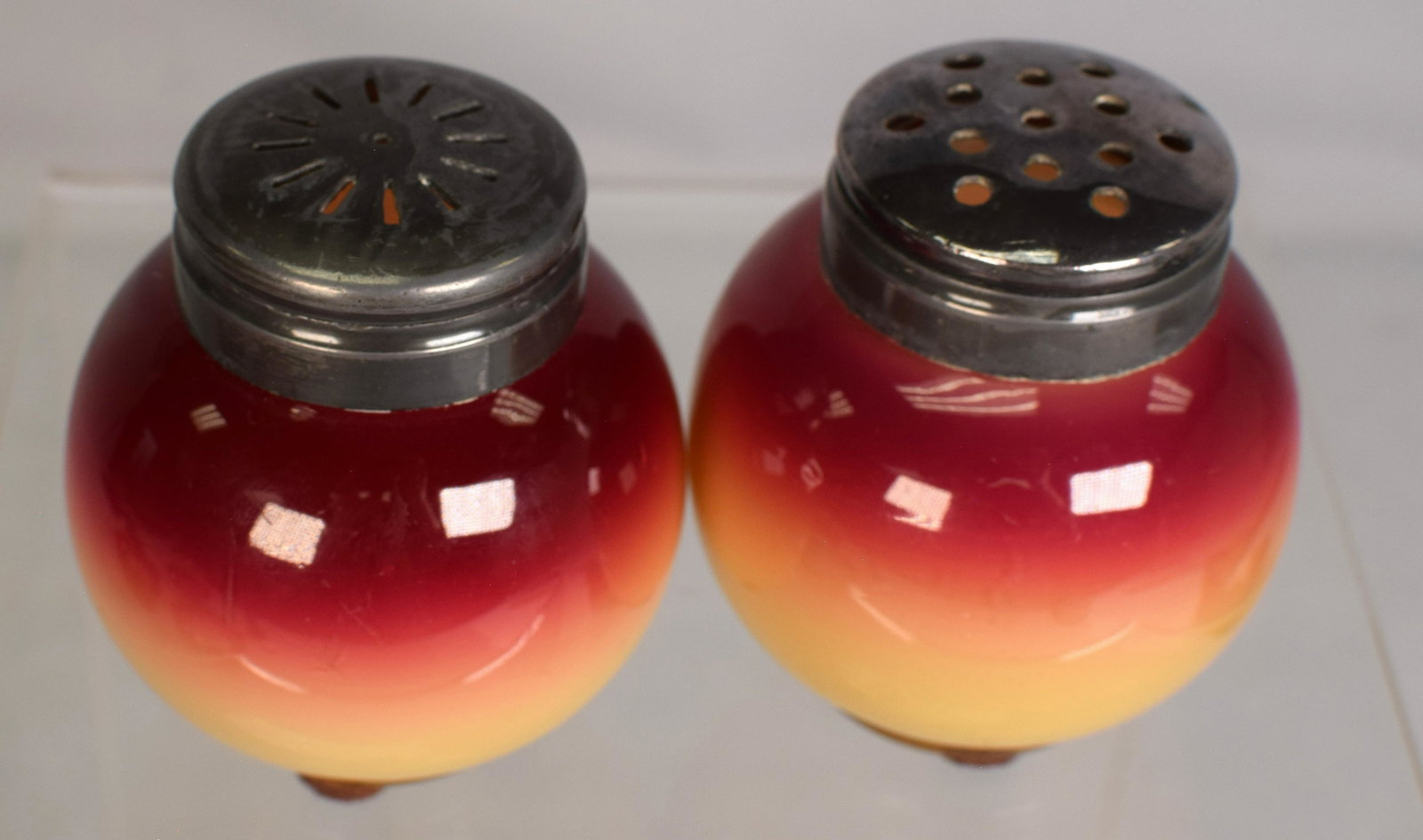 RARE NEW ENGLAND PLATED AMBERINA SALT & PEPPER: Unusual pear shape amberina plated salt and pepper. Silver-plated tops. 2 1/2 inches. Minor defects/scratches on glaze. Ground pontil.