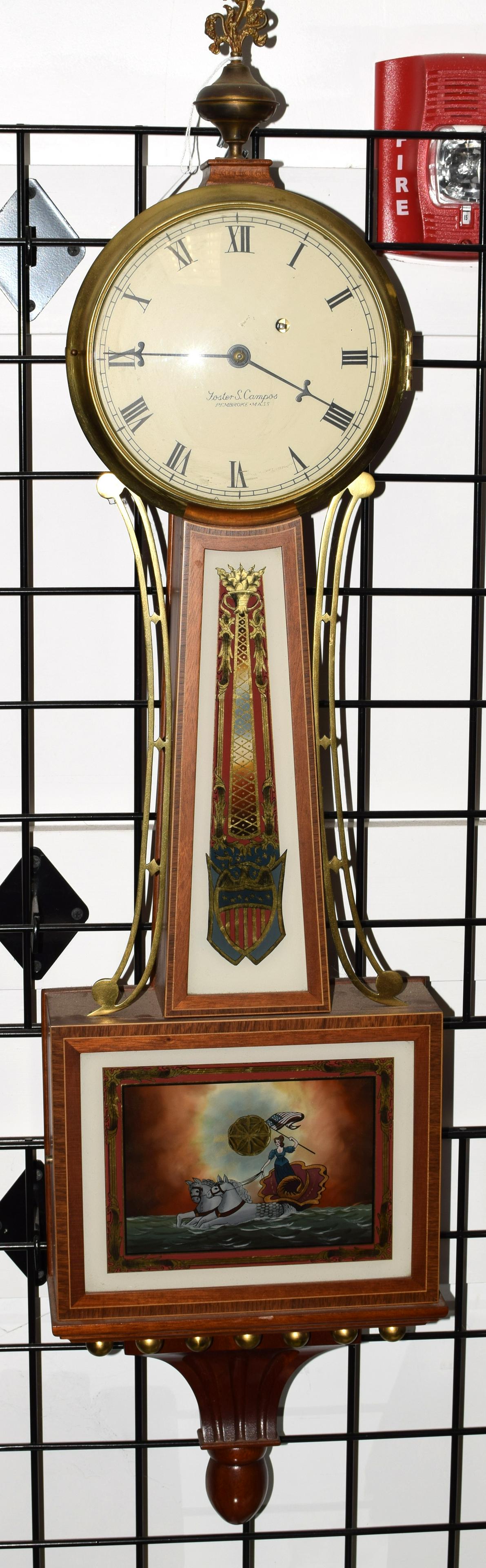 FOSTER CAMPOS CROSS BANDED BANJO CLOCK: 1979 date, mahogany case. Clock number 37 and made in 1979.Painted face with Roman Numerals signed Foster Camos, Pembroke, Mass. Reverse painted panel with mythilogical female figure in a shell chario