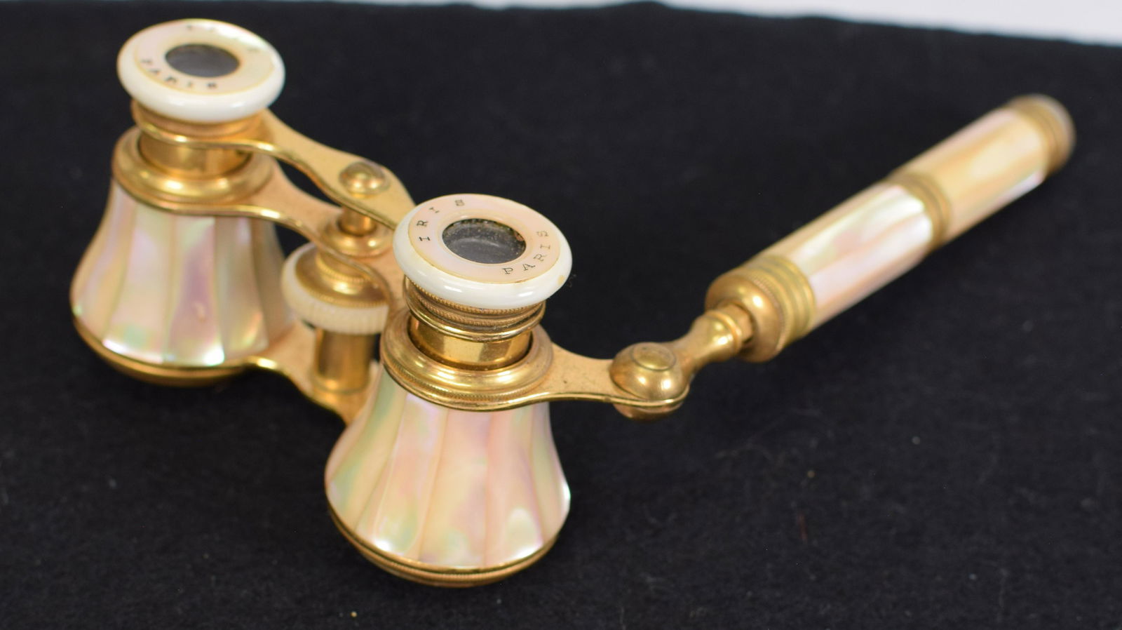 FRENCH IRIS MOTHER OF PEARL OPERA GLASSES: French Iris opera glasses, with extension handle, brass with mother of pearl inlay, marked on eyepiece "Iris Paris." 5.25" W x 8" L. Good condition and working.