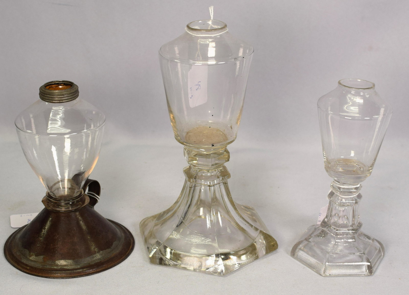 (ON-3) EARLY 19TH WHALE OIL LAMPS: Consists of 1) Clear colorless glass lamp with waffer construction. 6 1/2 inches tall. Six sided base. Good condition. 2) Clear colorless glass lamp with waffer construction. Six sided base. 8inches t