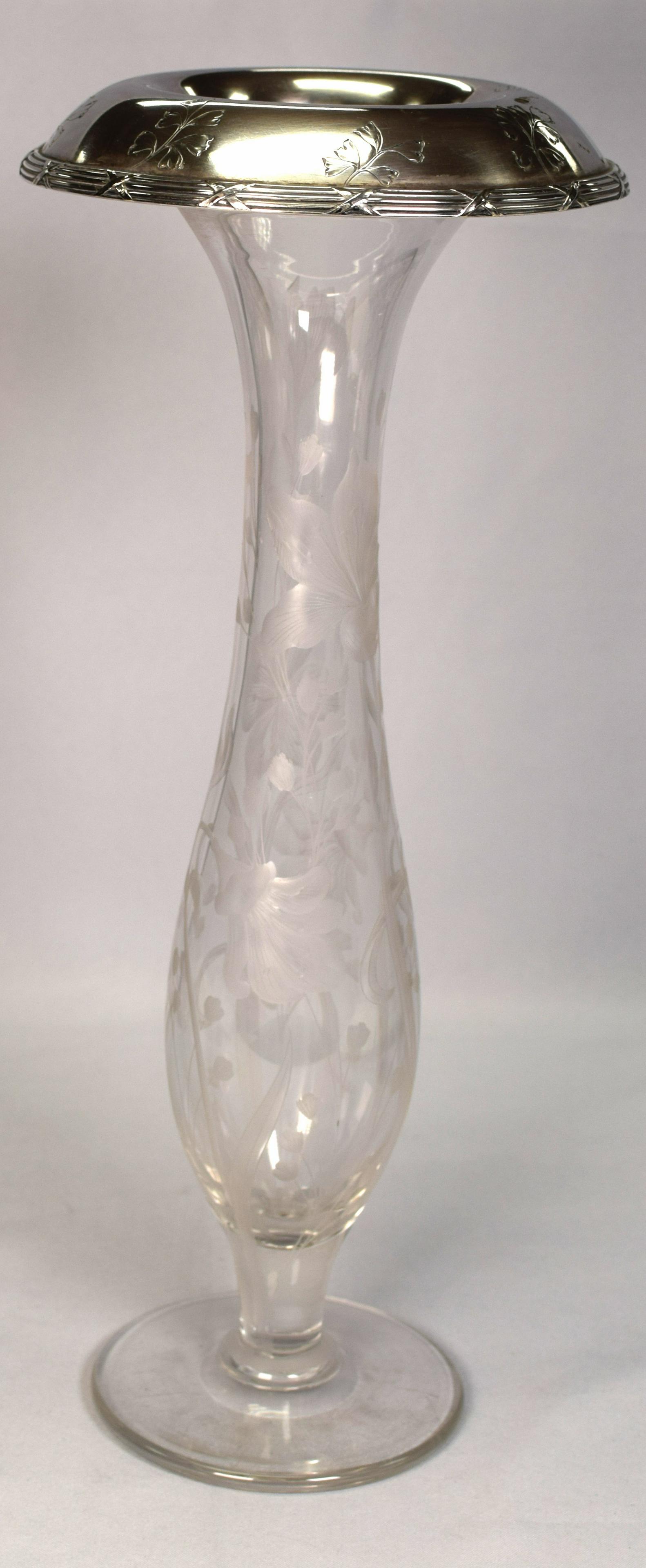 TALL INTAGLIO ABCG CUT STERLING TOP FOOTED VASE: 16 1/2 inches tall. Polished pontil. Floral Hawkes intaglio cut with over hanging sterling top. Gorham sterling sterling mark and numbered Flared top 6 1/2 inches wide, weighs 4 lbs. Goodcondition.