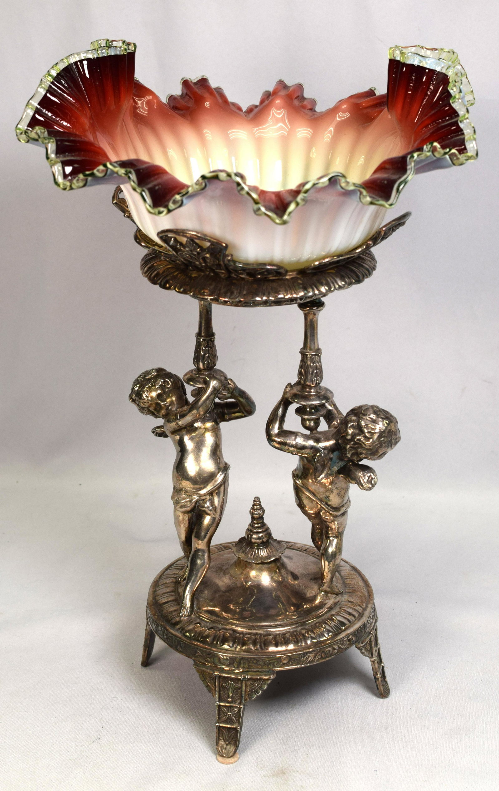RARE RUBINA ART GLASS & SILVERPLATE BRIDES BASKET: Circa 19th century. Victorian figural winged putti silver plate and Rubina art glass basket. Polished pontil. basket marked Meridan. Measures approx.16 1/2 inches tall, weighs approx. 6lbs.Good condit
