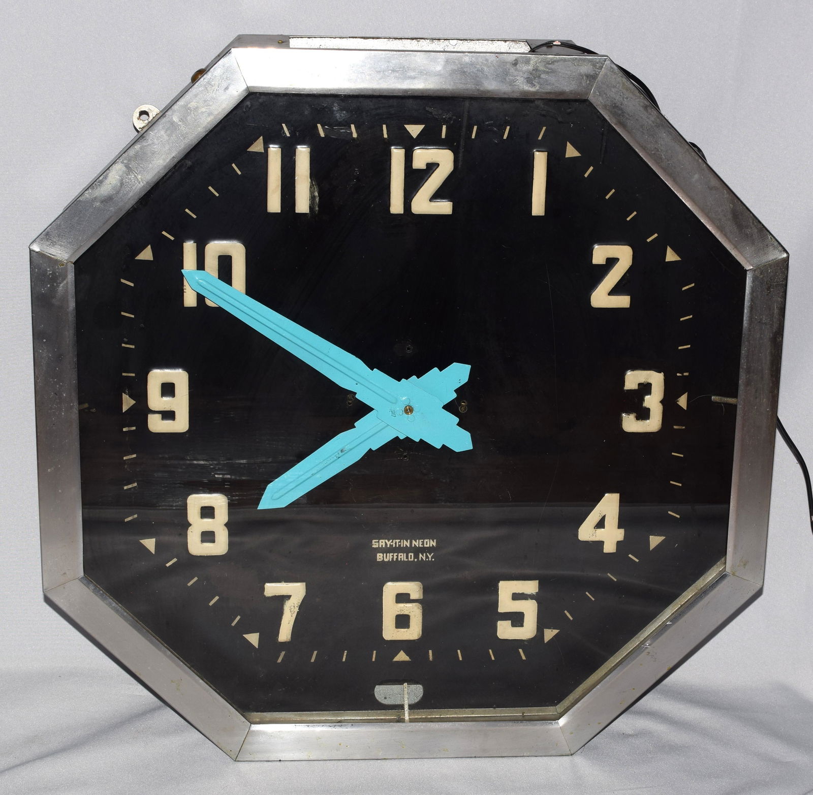 LARGE 1940'S "SAY IT IN NEON" ART DECO WALL CLOCK: Ca 1940's. six sided octagonal form. Metal and glass. 25 inches x 25 inches x 7 inches deep. 23 pounds. Electric clock was plug it in and is working. Not a lighted face. Original silveredcase. Face si