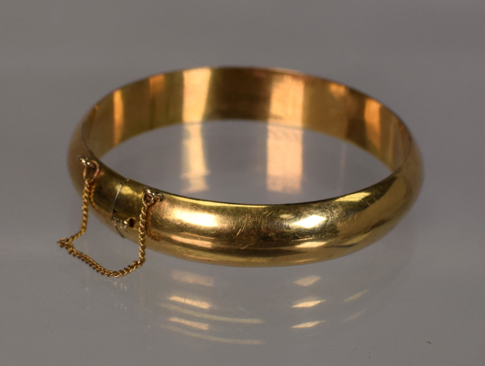 8K YELLOW GOLD BRACELET: Marked and test 8k. 1/2 inches. inside diameter 2 3/8 inches. Approx. 27 grams or 17.36 pennyweight. Minor surface scratch and very minor small dents. clasp and chain good condition