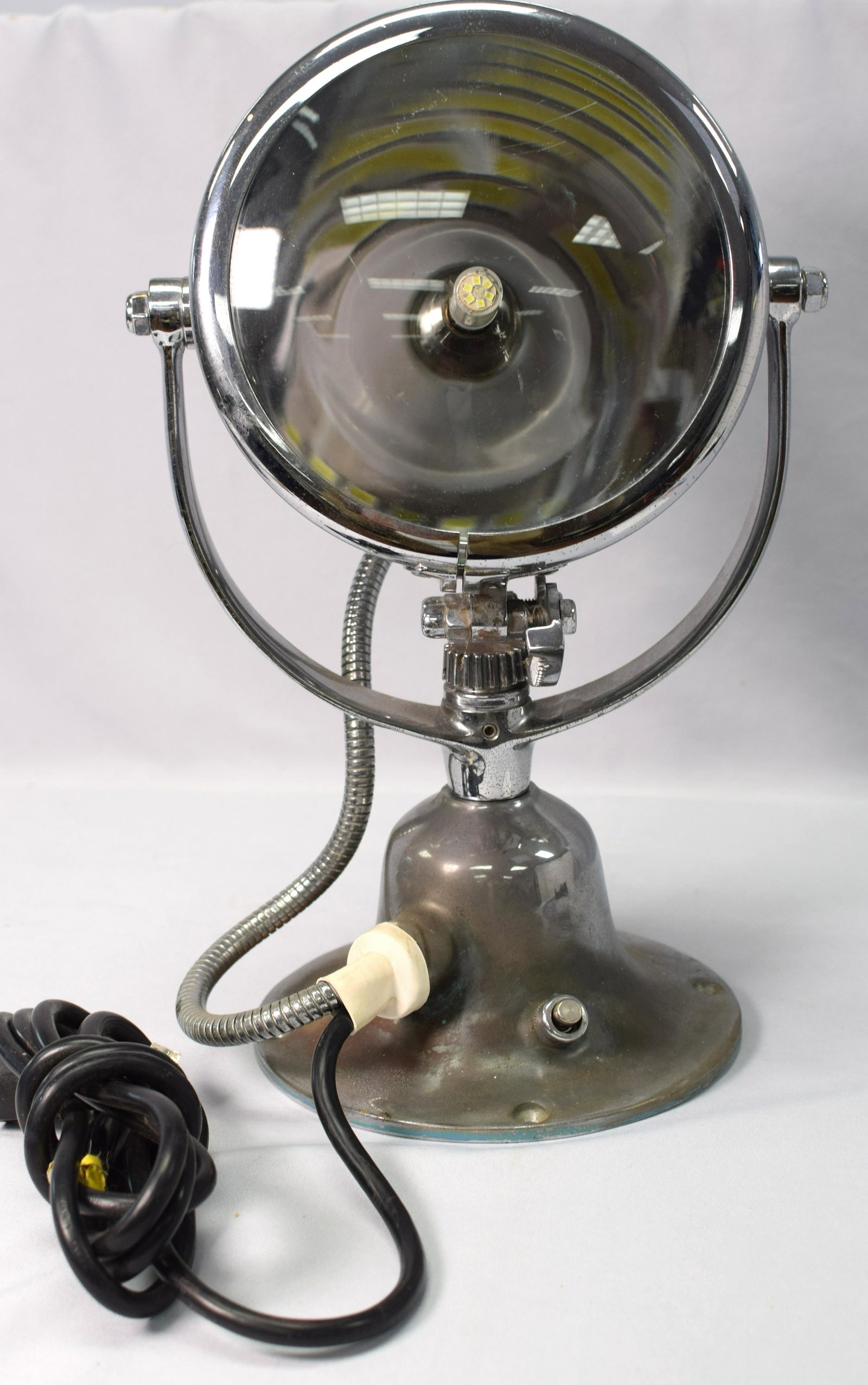 CHROME PLATED BRASS SPOTLIGHT: Chrome plated boat spotlight with yoke and flange. Original clear lens. Maker "Half Mile Ray, New York, NY". Dimensions: 7" diameter, 16" tall. 15 pounds. Working and very bright. Good condition.Sligh