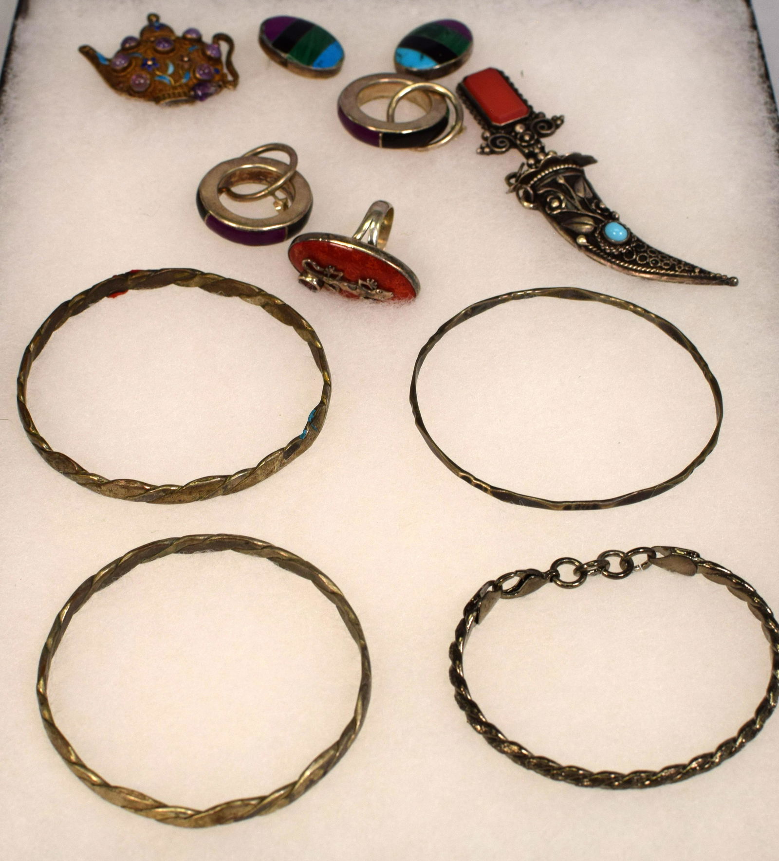 MISC. SILVER & GEMSTONE VINTAGE JEWELRY: Consists of 1) Four sterling silver bracelets. 2) Two pairs of gemstone pierce earrings. Silver ring with lizard. 3) Dagger brooch. Gold wash Jewel and enamel teapot. All pieces are silver. Goodcondit